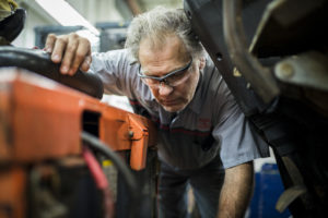Mechanical technician evaluating the steering system of a Toyota forklift
